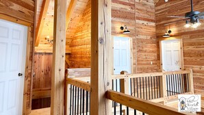 A wooden interior with a staircase, wooden doors, and a railing. - Dreams Park/All Star- Sunset Lodge at Old World Village (Maryland)