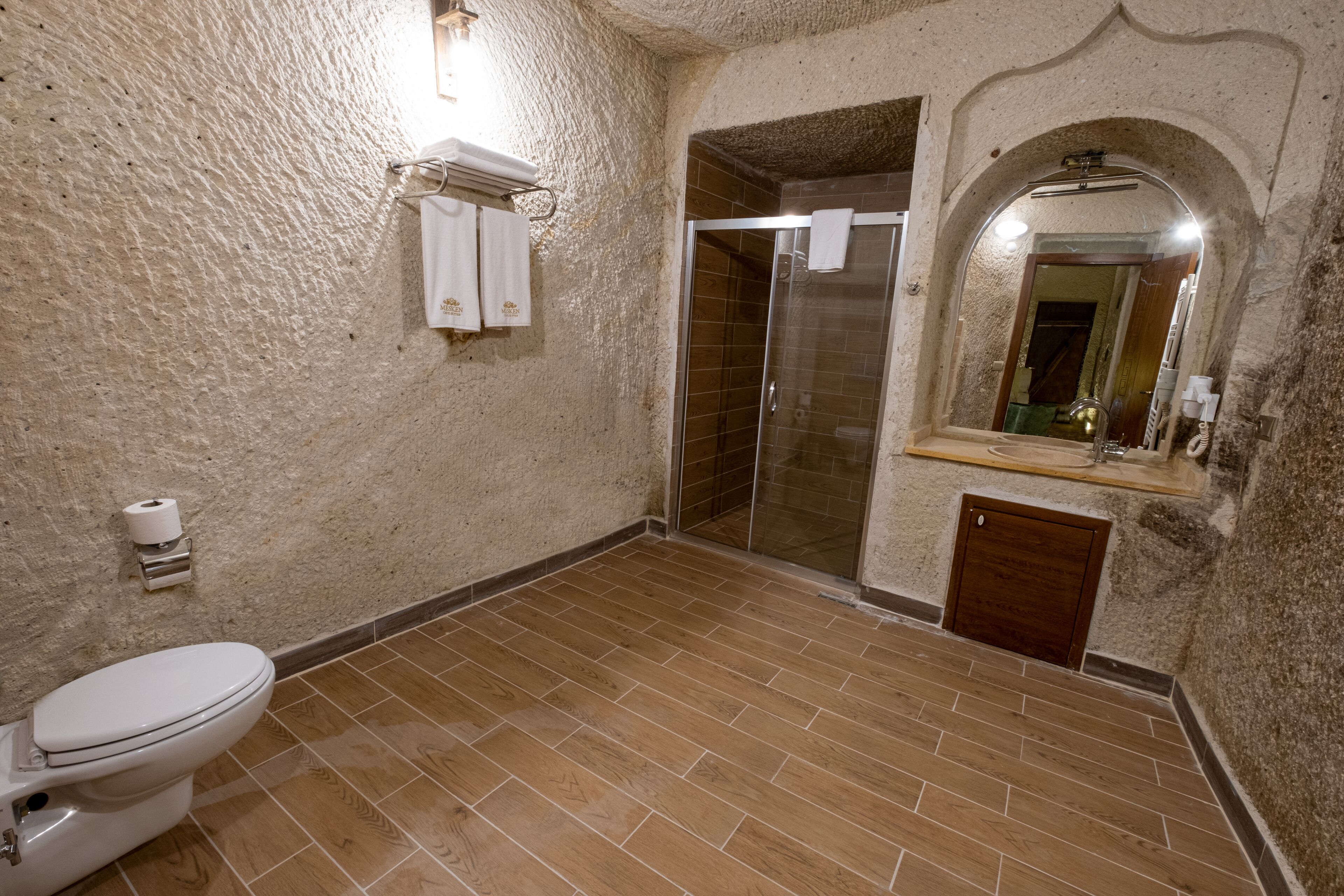 A bathroom with a toilet, shower, and sink.
