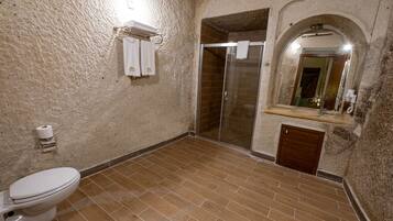 A bathroom with a toilet, shower, and sink.