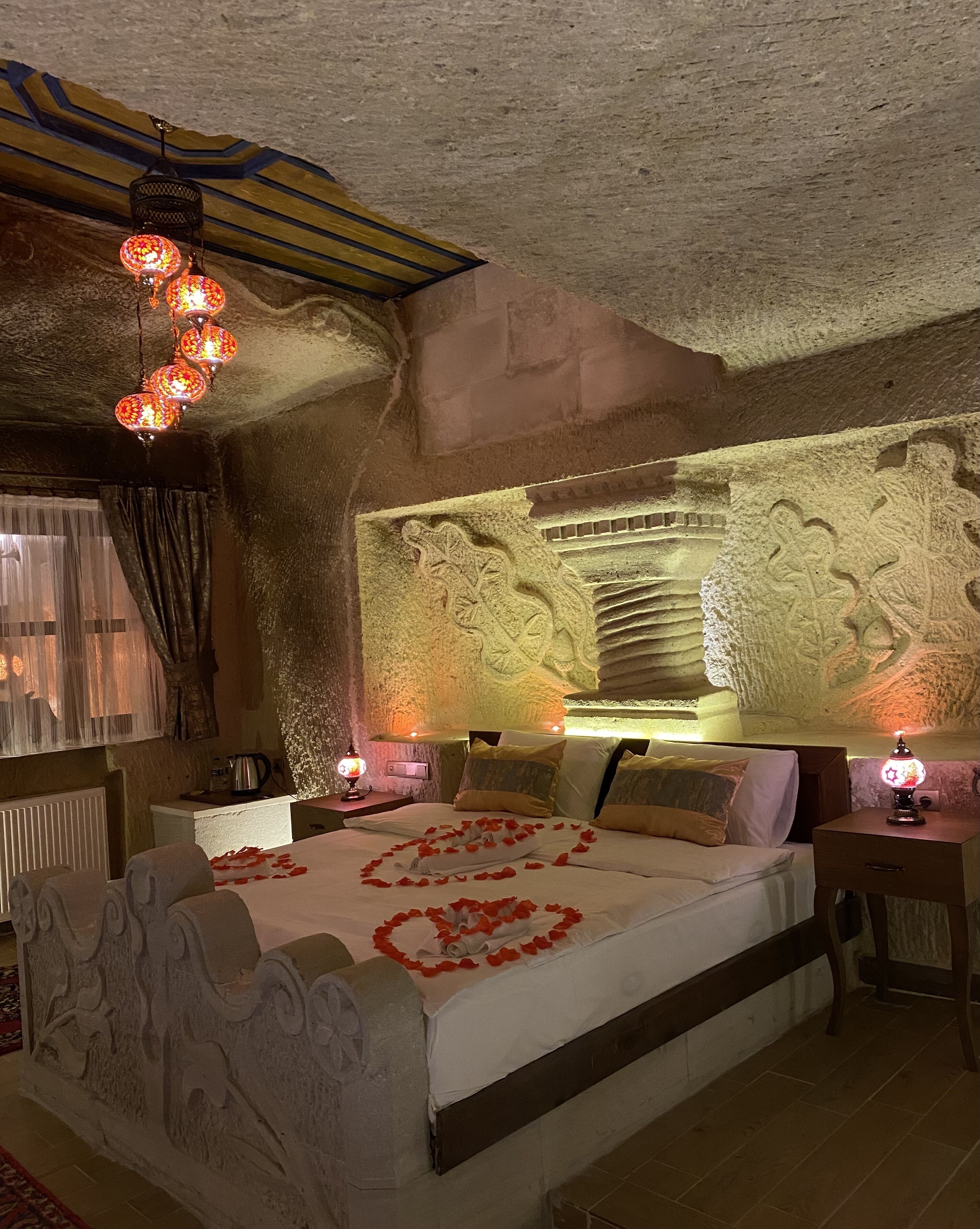 A room with a bed, decorative wall carvings, and a unique ceiling design.