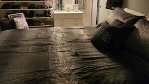 Un dormitorio con una cama, un armario con zapatos y un maniquí.