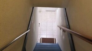 Una escalera con barandillas a ambos lados que conduce a una puerta al final.
