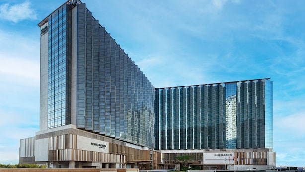 Een modern hotel met een opvallend hoekig ontwerp, met een grote glazen gevel en een prominent Sheraton bord.