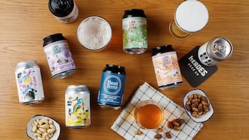 Variedad de bebidas y aperitivos sobre una mesa de madera.