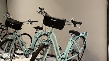A room with two bicycles leaning against a wall.