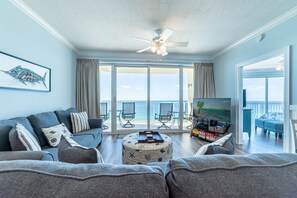 Relax in this ocean-view living room with a comfortable sofa, flat-screen TV, and balcony access.