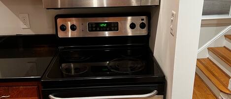 A kitchen with a stainless steel microwave, oven, and stovetop.