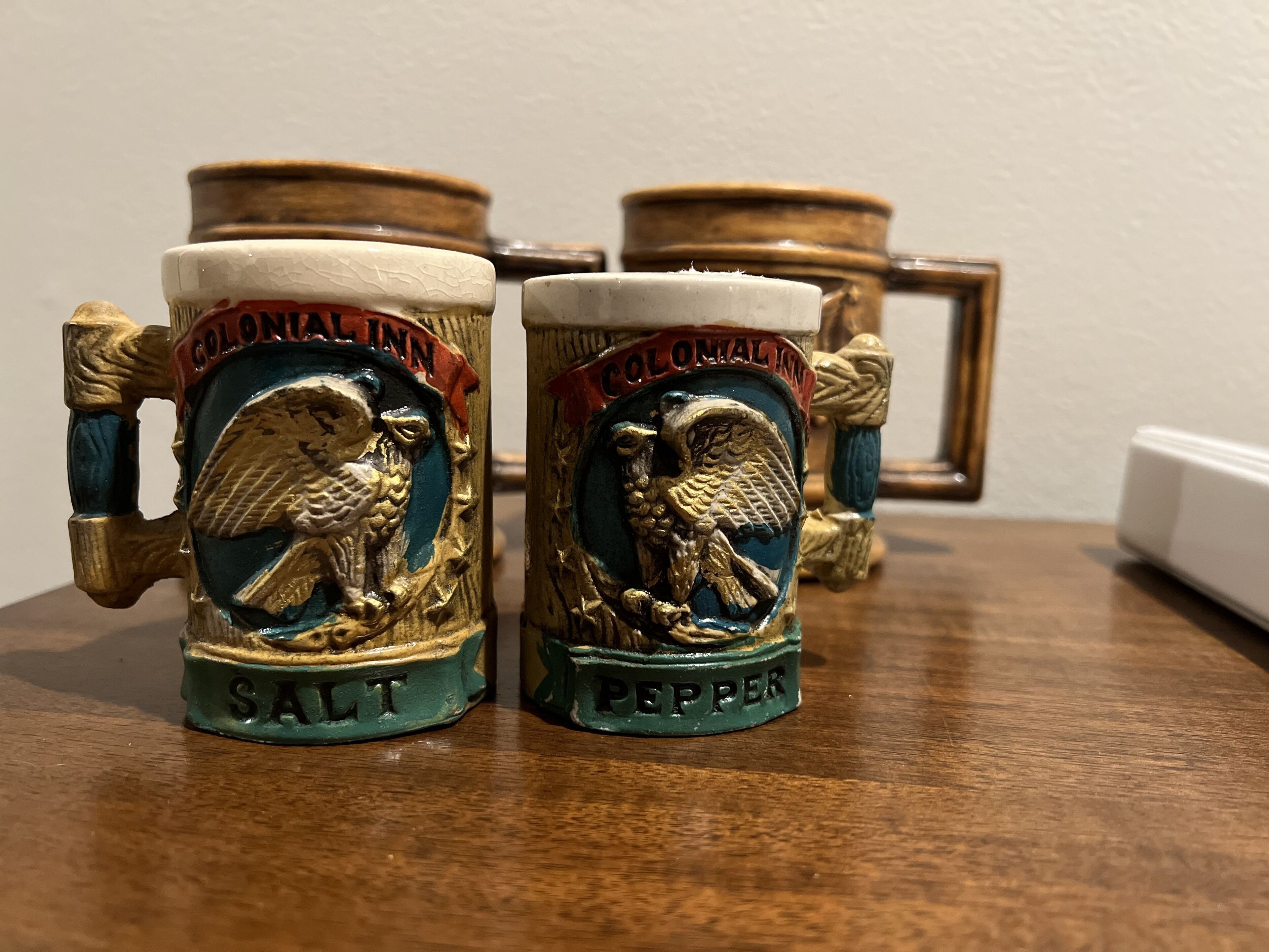 Two salt and pepper shakers on a wooden table.