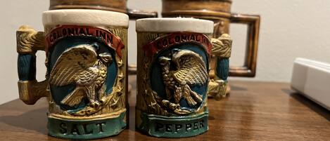 Two salt and pepper shakers on a wooden table.