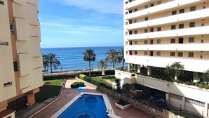 Un hotel con piscina, vistas al océano y palmeras.