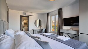 Een hotelkamer met twee bedden, een bureau, een televisie en een raam met uitzicht.