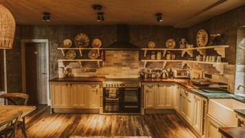 A kitchen with wooden cabinets, a built-in oven, and shelves with dishes.