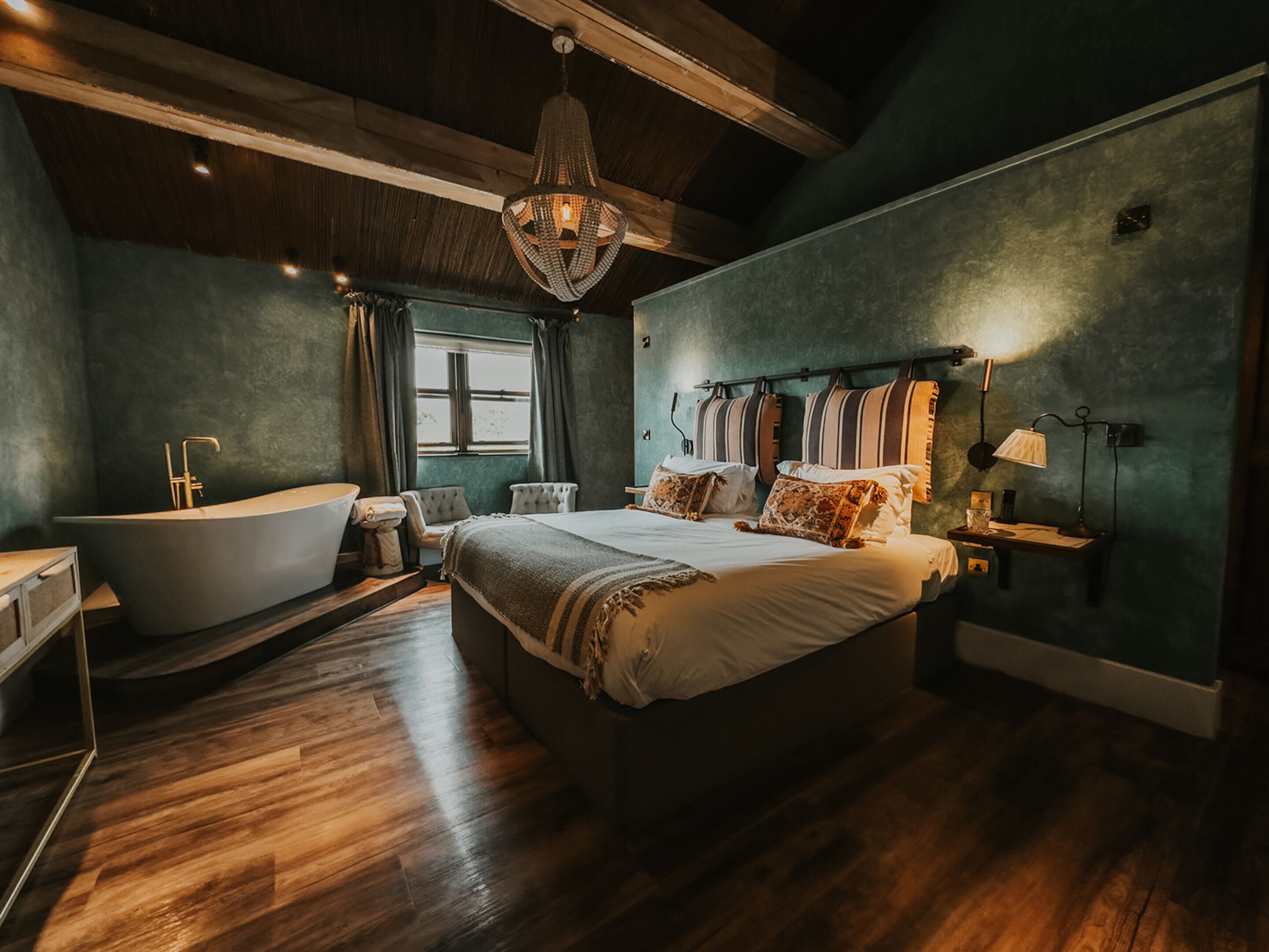 Une chambre avec un grand lit, une baignoire et une fenêtre.