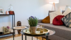 A modern living room with a round coffee table, a potted plant, and a lamp. - EG L 70m2 2-Zimmer Wohnung (Freilassing)
