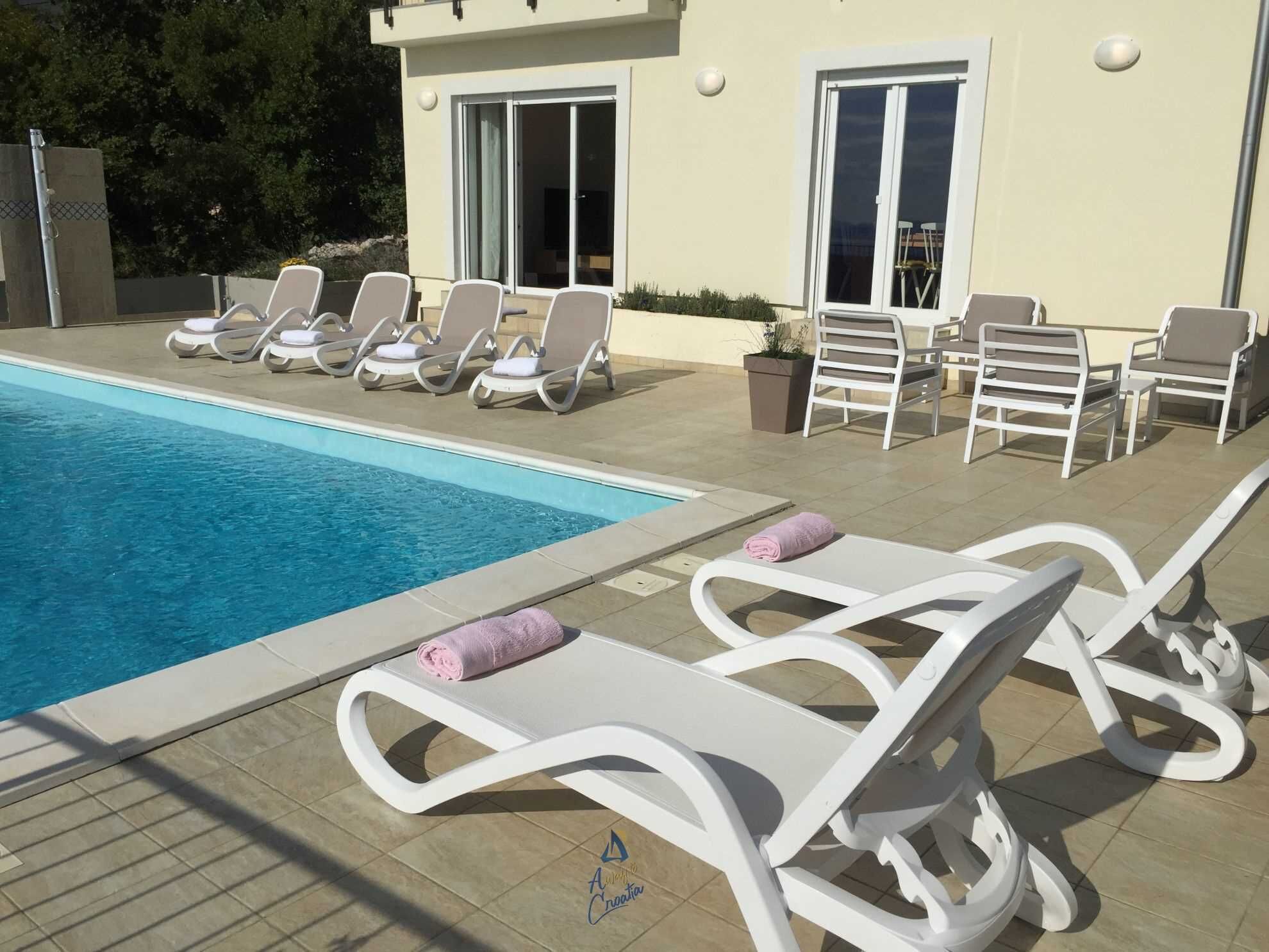 A poolside area with lounge chairs and a pool.