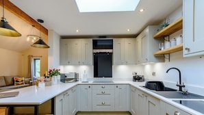 A modern kitchen with a skylight, wooden beams, and a central island. - 2 bedroom accommodation in Thornton le Dale, near Pickering (Thornton le Dale, near Pickering)