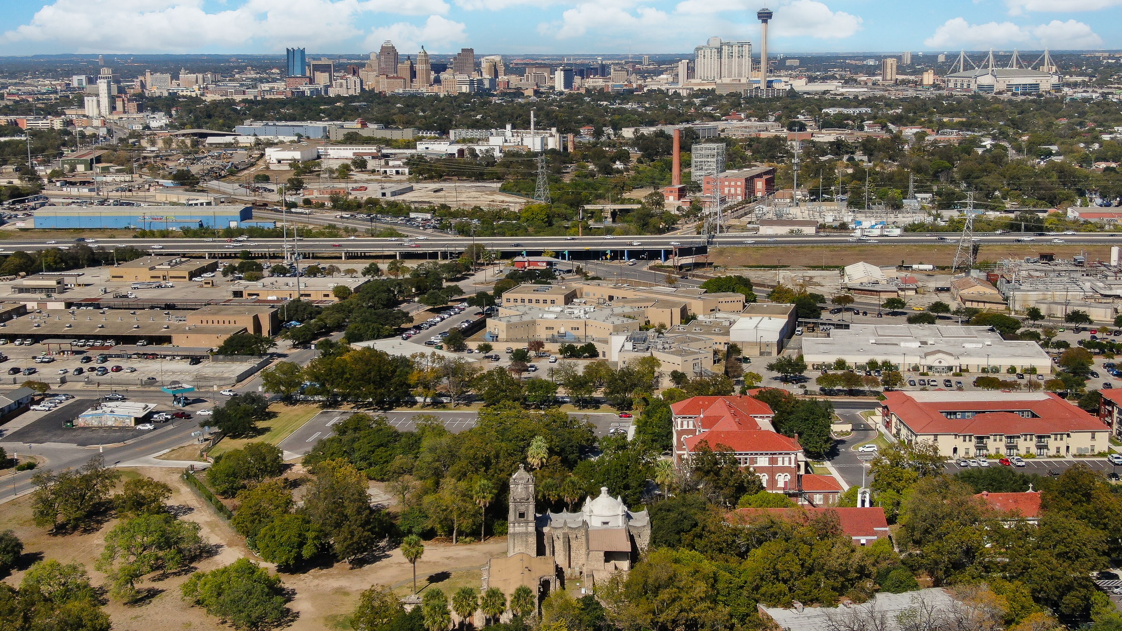 A cityscape with a prominent tower, a stadium, and a mix of commercial and residential buildings.