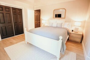 A bedroom with a bed, bedside tables, a mirror, and a door. - Spacious 4 bedroom Guest House with Hot Tub (Clare)