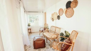 A room with wicker furniture, a brown ottoman, and woven wall decorations. - Spacious 4 bedroom Guest House (Clare)