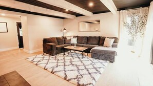 A living room with a sectional sofa, a coffee table, and a patterned rug. - Spacious 4 bedroom Guest House (Clare)