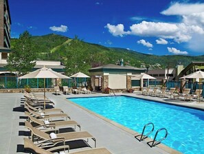 Relax by the pool surrounded by lounge chairs and umbrellas, with breathtaking views of the surrounding mountains.