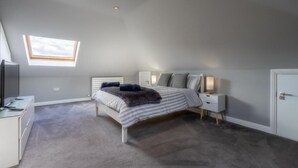 A bedroom with a bed, bedside tables, a desk, and a window. - Immaculate Family sized holiday home located 10mins from beachfront! (Edinburgh)