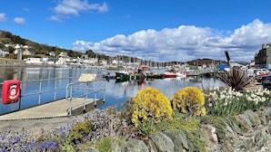 Un port avec des bateaux, un quai et un mur de pierre orné de fleurs.