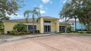A yellow building with a flat roof, large windows, and a gated entrance. - Huge screened patio that overlooks Lake Buck, near famous attractions!! (Kissimmee)