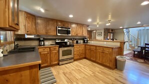 A modern kitchen with wooden cabinets, stainless steel appliances, and a wooden floor. - Mountain Vintage Vacation Home! Conveniently in Mt CB, easy access to trails! (Crested Butte)