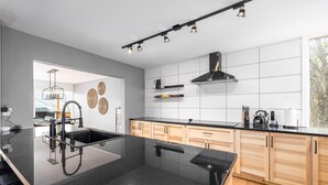 A modern kitchen with a black granite countertop, wooden cabinets, and a stainless steel range hood. - Bryce Resort Retreat in Shenandoah w/ Amazing Views  (Basye)