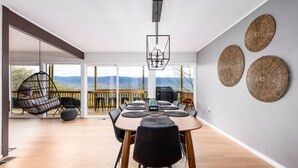 A modern dining area with a large table, black chairs, and a hanging light fixture. - Bryce Resort Retreat in Shenandoah w/ Amazing Views  (Basye)