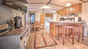 A kitchen with wooden cabinets, a built-in stove, and a bar area.