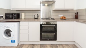 Une cuisine moderne équipée d’un lave-linge, d’un four à micro-ondes, d’une cuisinière et d’un four.