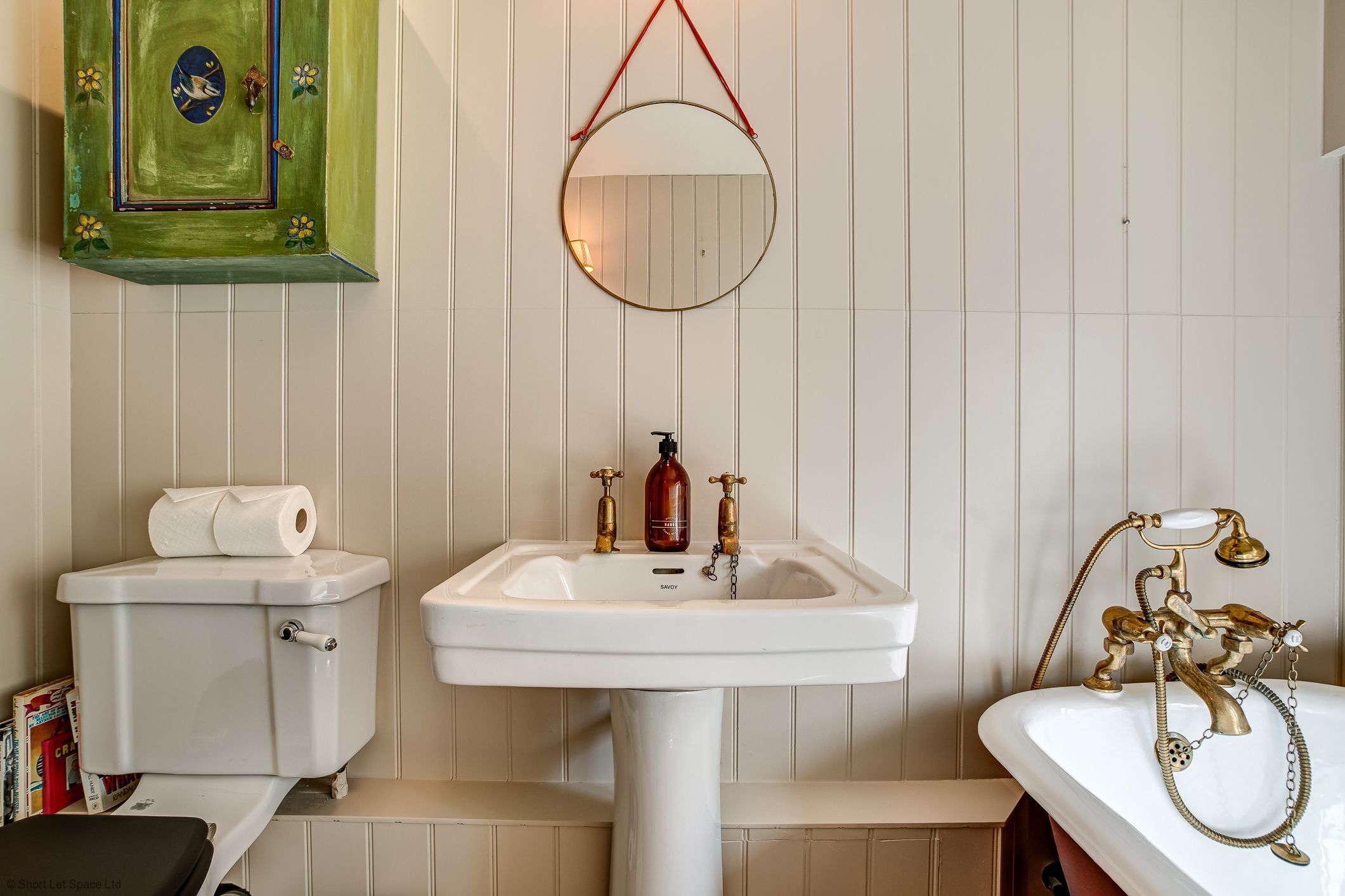 A bathroom with a toilet, sink, and bathtub.