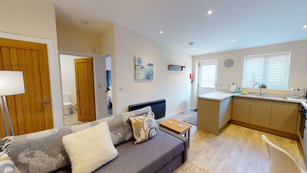 Un apartamento moderno con sala de estar, kitchenette y baño.