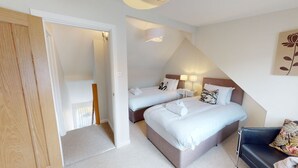 Une chambre d’hôtel avec deux lits, un canapé et une petite table.
