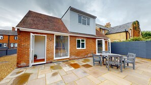 A two-story house with a patio area featuring a table and chairs. - Mill Stream Passage | Oxford Holiday Let | 3 Beds & Sleeps 5 (Wolvercote, Near Oxford)