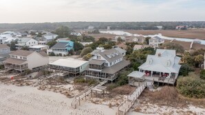 A coastal residential area with houses featuring balconies and decks, connected by wooden walkways. - High Tide - Beachfront Home in "Arrogantly Shabby" Pawleys Island, SC (Pawleys Island)