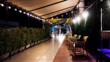Un espacio al aire libre cubierto con sillas y un mural de fondo.