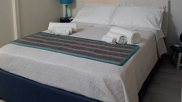 Une chambre à coucher avec un lit, une table de chevet, une lampe et une armoire.