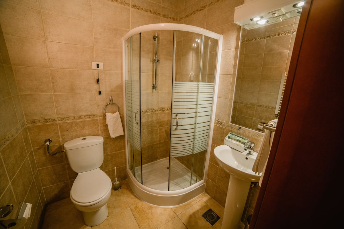 Une salle de bain avec une douche à parois de verre, des toilettes et un lavabo.