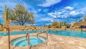 A pool area with a sign indicating it is for adults only, surrounded by lounge chairs and cacti.