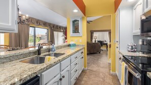 A modern kitchen with granite countertops, a double sink, and a built-in oven.