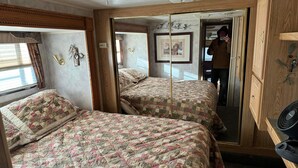 Ein Schlafzimmer mit zwei Betten, einem Holzschrank und einem Spiegel.