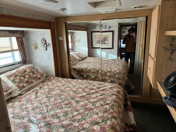 A bedroom with two beds, wooden wardrobe, and a mirror. - Wickenburg Arizona 5th wheel (Wickenburg)