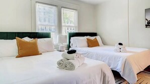 A hotel room with two beds, white bedding, and a green headboard. - Completely Updated Home-sleeps 6-Centrally Located (Cincinnati)