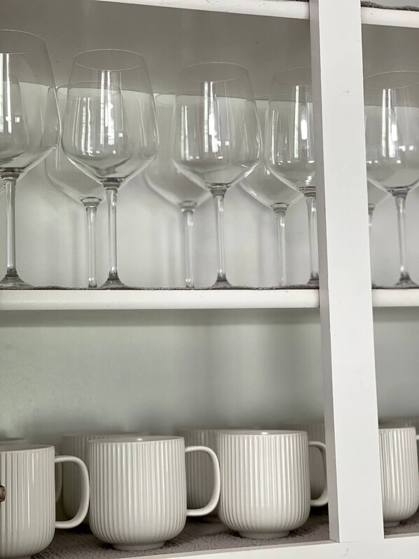 A shelf with wine glasses and white mugs. - Beautiful home in the Heart of Five Forks, Simpsonville! (Simpsonville)