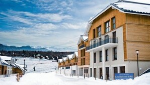 A hotel with a modern design, featuring a wooden facade and balconies. - Appart Cozy Près des Pistes! | Sauna Sur-Place (La Féclaz)
