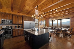A spacious kitchen with wooden cabinets, a large island, and a dining area with a view.