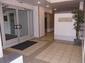 Welcome to Residence Arc en Ciel 2, where a clean and modern design greets you at the reception desk with a clear view of the interior.